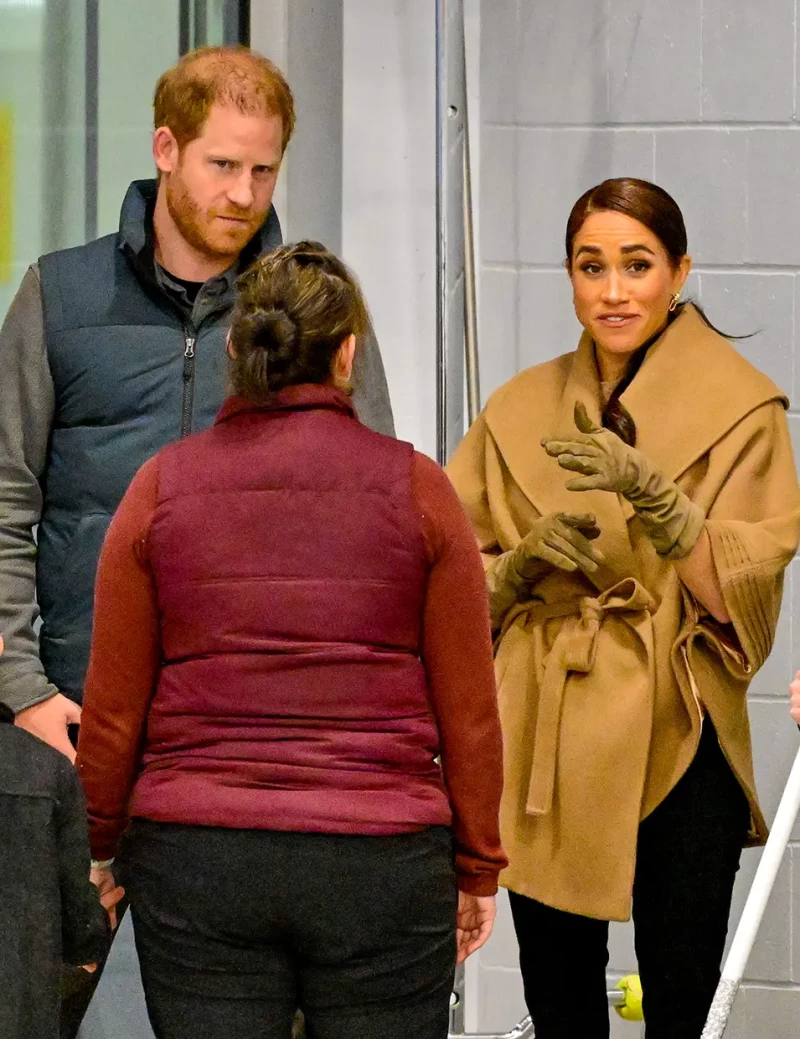 Meghan y el príncipe Harry hablando con una empleada