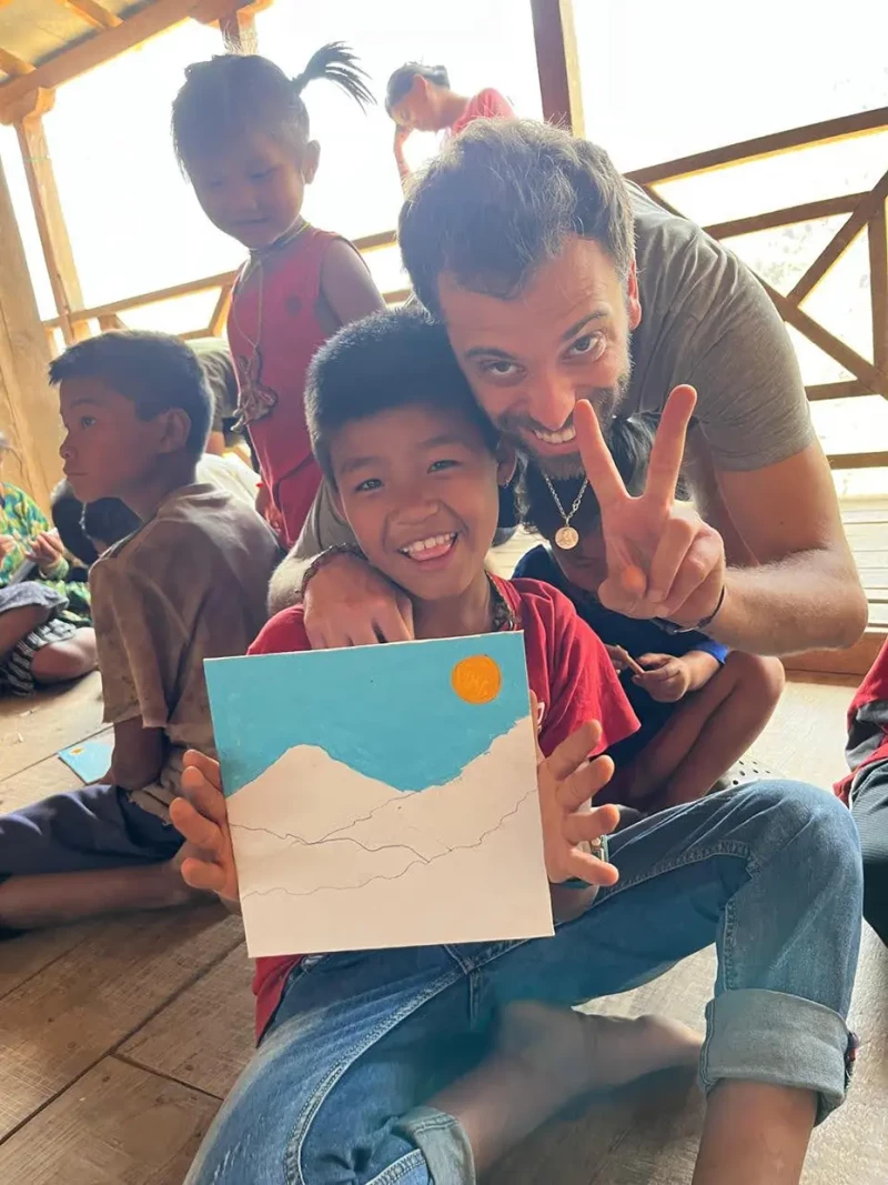 Un niño nepalí enseñando un cuadro que ha pintado junto a Nacho Puig Aubeyzon, CEO de Bahadur Social Project.
Social Project)