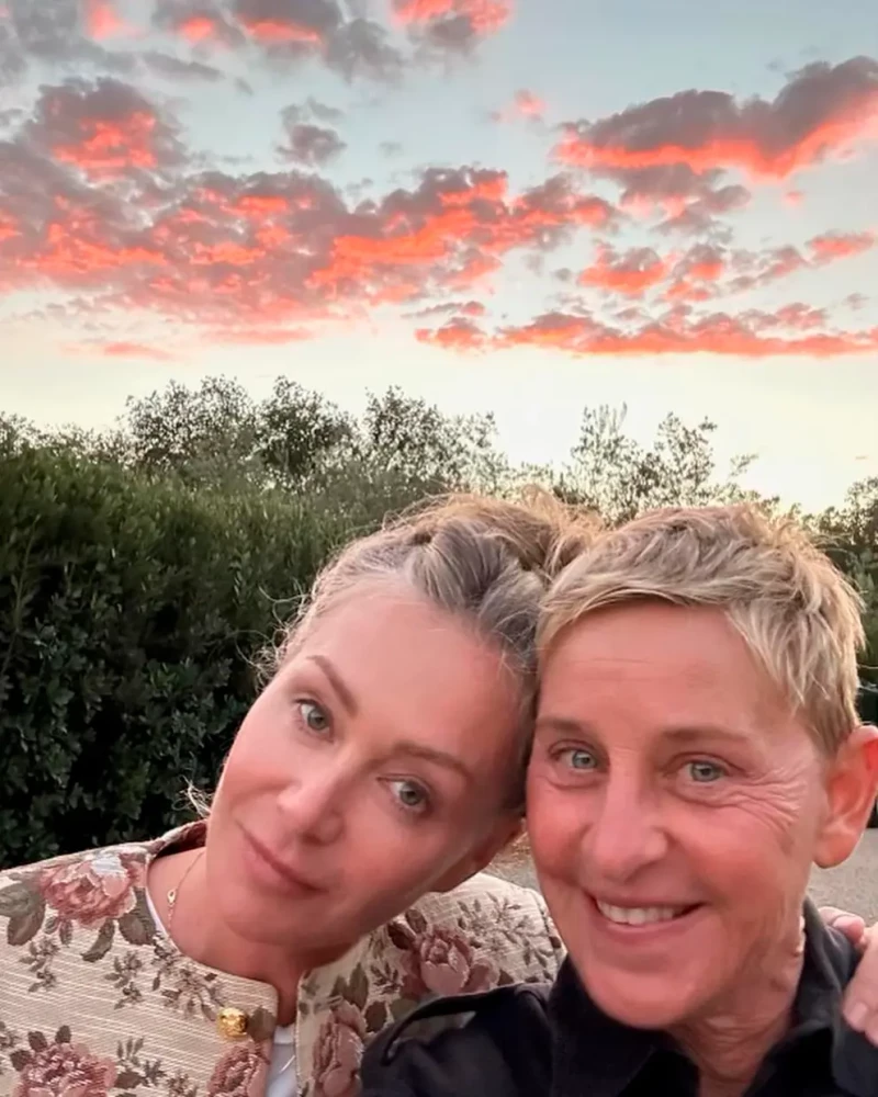 Ellen DeGeneres y su pareja posando ante una puesta de sol.