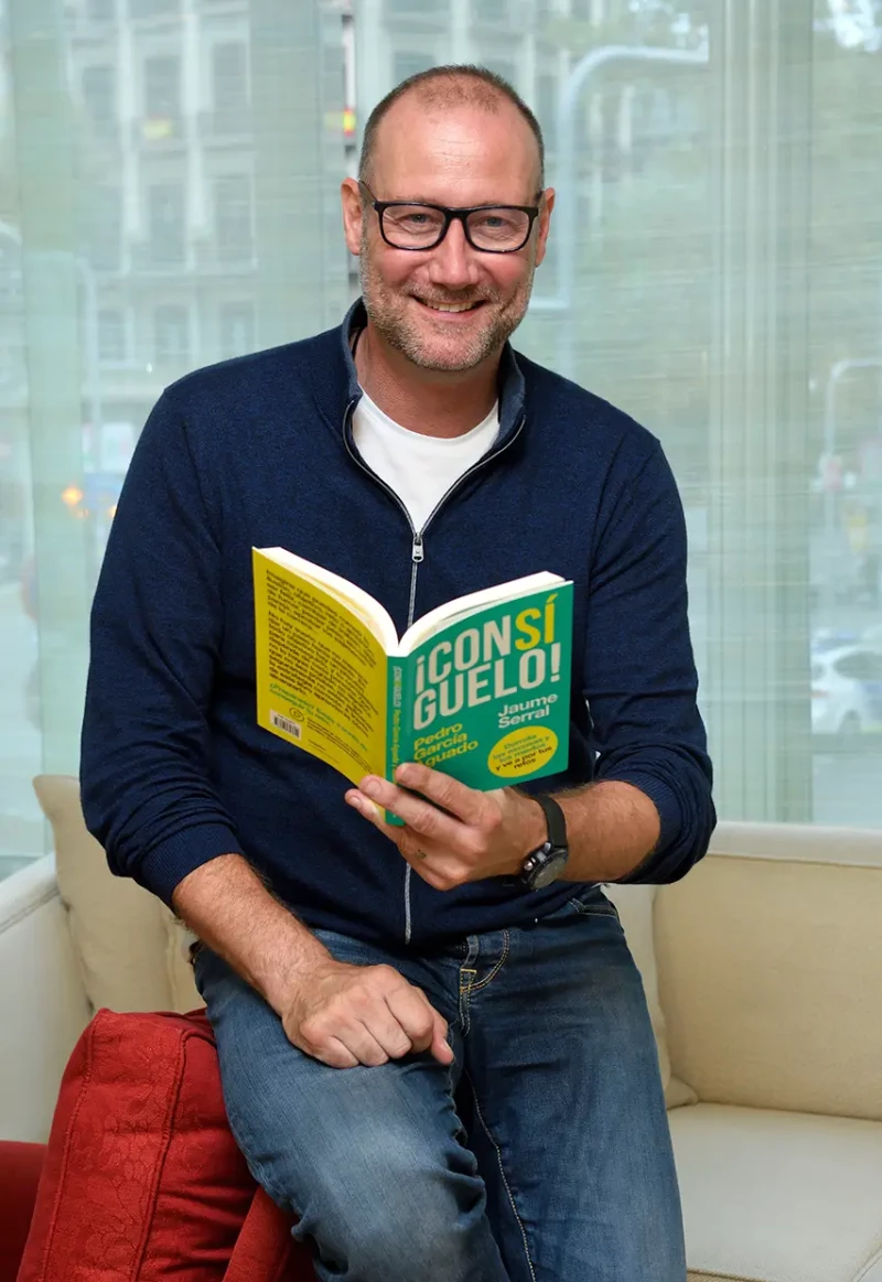 Pedro García Aguado posando con un libro escrito por él.