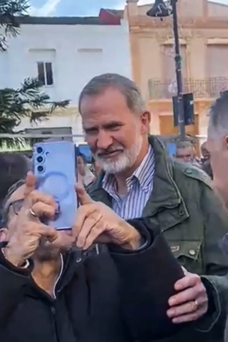 El rey Felipe tomándose un "selfie" con un señor.