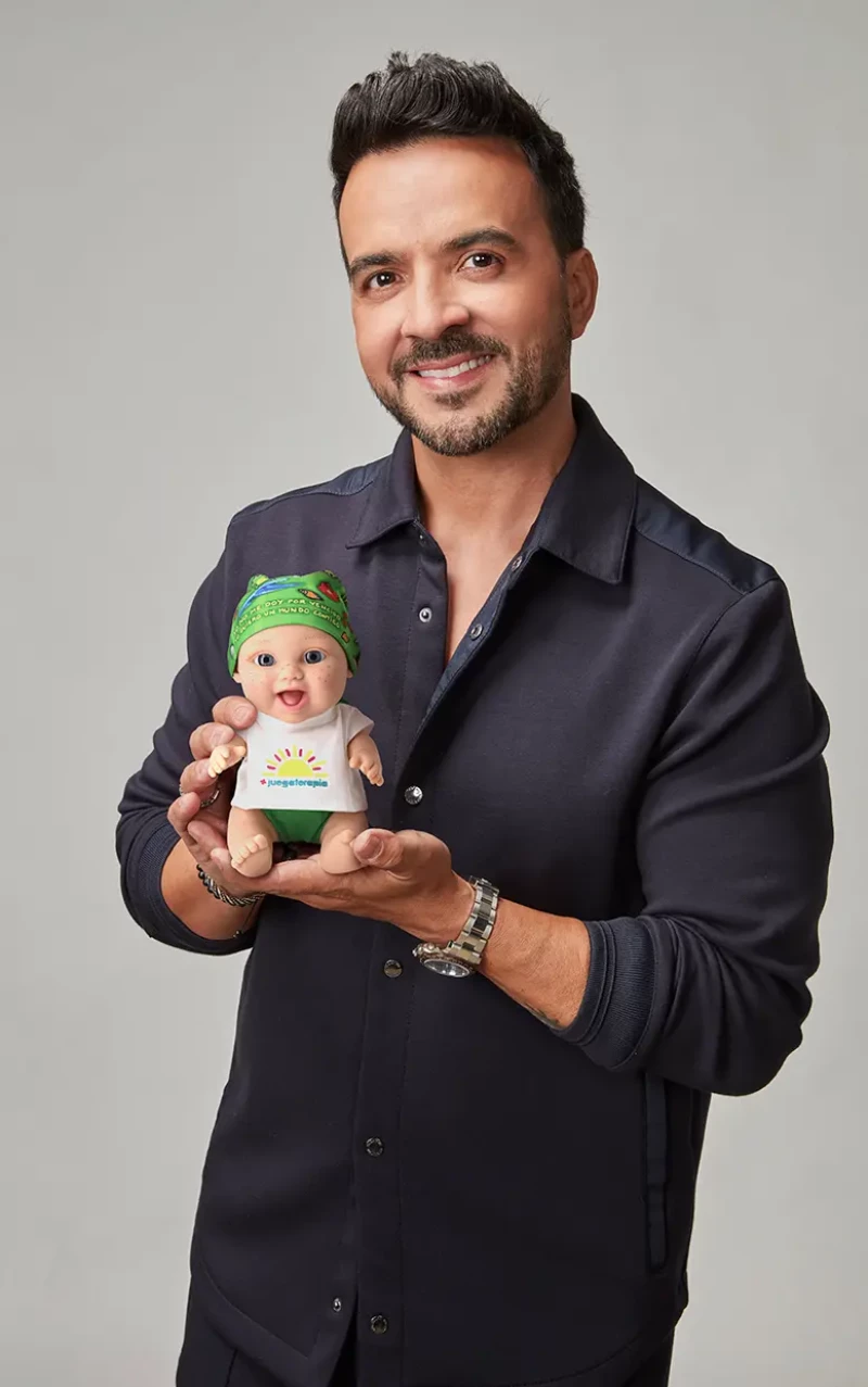 Luis Fonsi posa con el muñeco de bebé pelón.