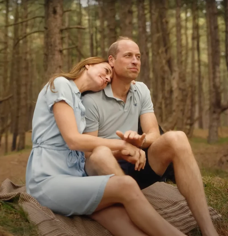 El Príncipe Guillermo y Kate Middleton abrazados en un bosque.