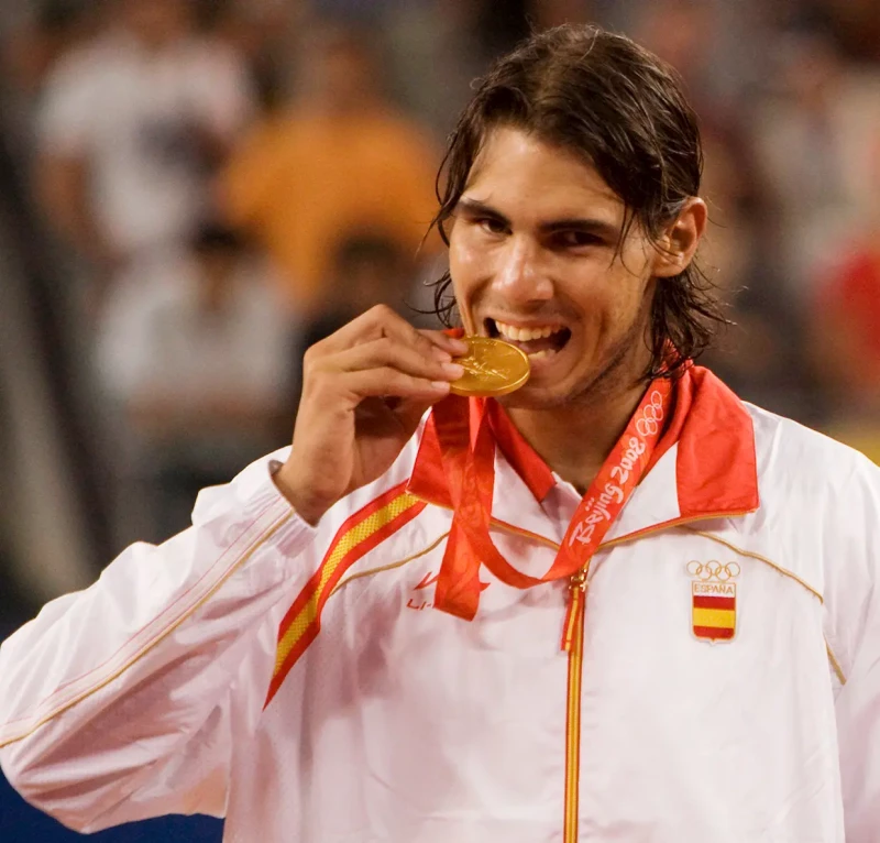 Rafa Nadal mordiendo una medalla de oro.