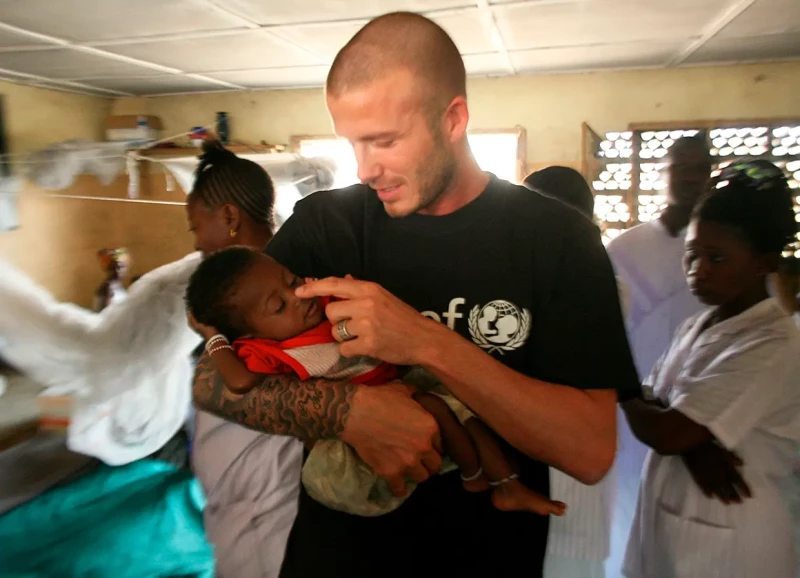 David Beckham con una niña bebé en brazos