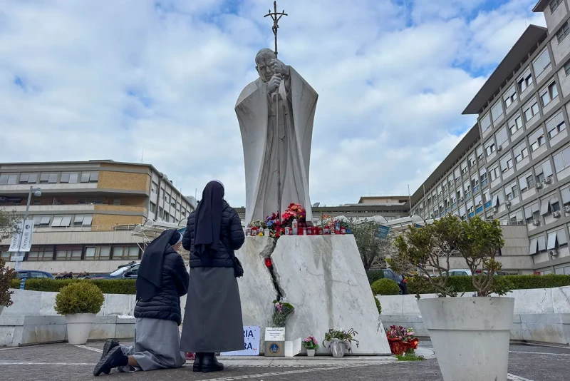 Religiosas rezan por la recuperación del Pontífice en un altar improvisado junto al hospital.