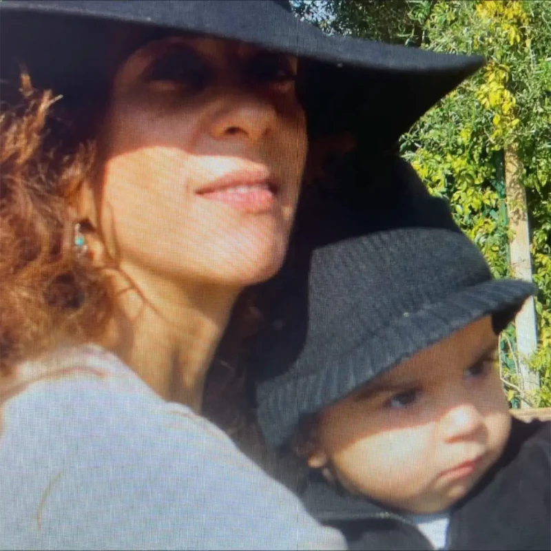 Rosario Flores con sombrero y con su hijo de bebe en brazos