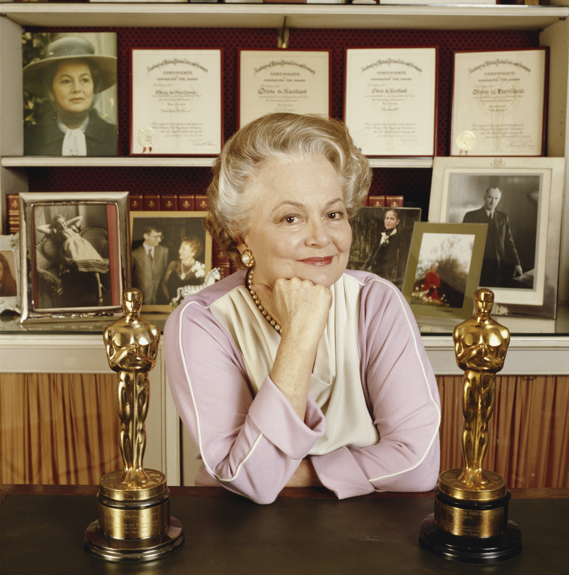 Olivia de Havilland junto a sus dos premios Oscar.