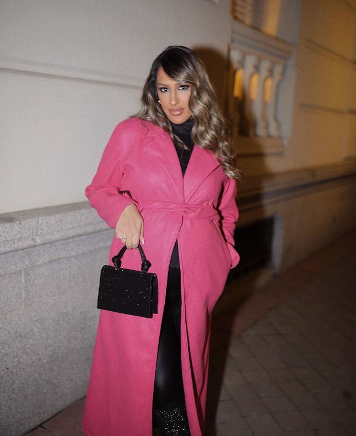 Noemí Salazar con un abrigo rosa y un bolso negro.