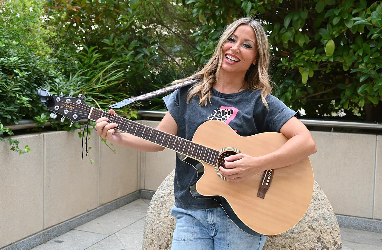 Verónica Romero sosteniendo una guitarra acústica.