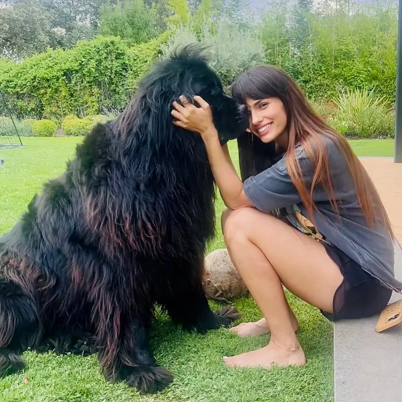 Sara junto a una de sus mascotas. Los perros también viven con ellos y disfrutan del jardín.