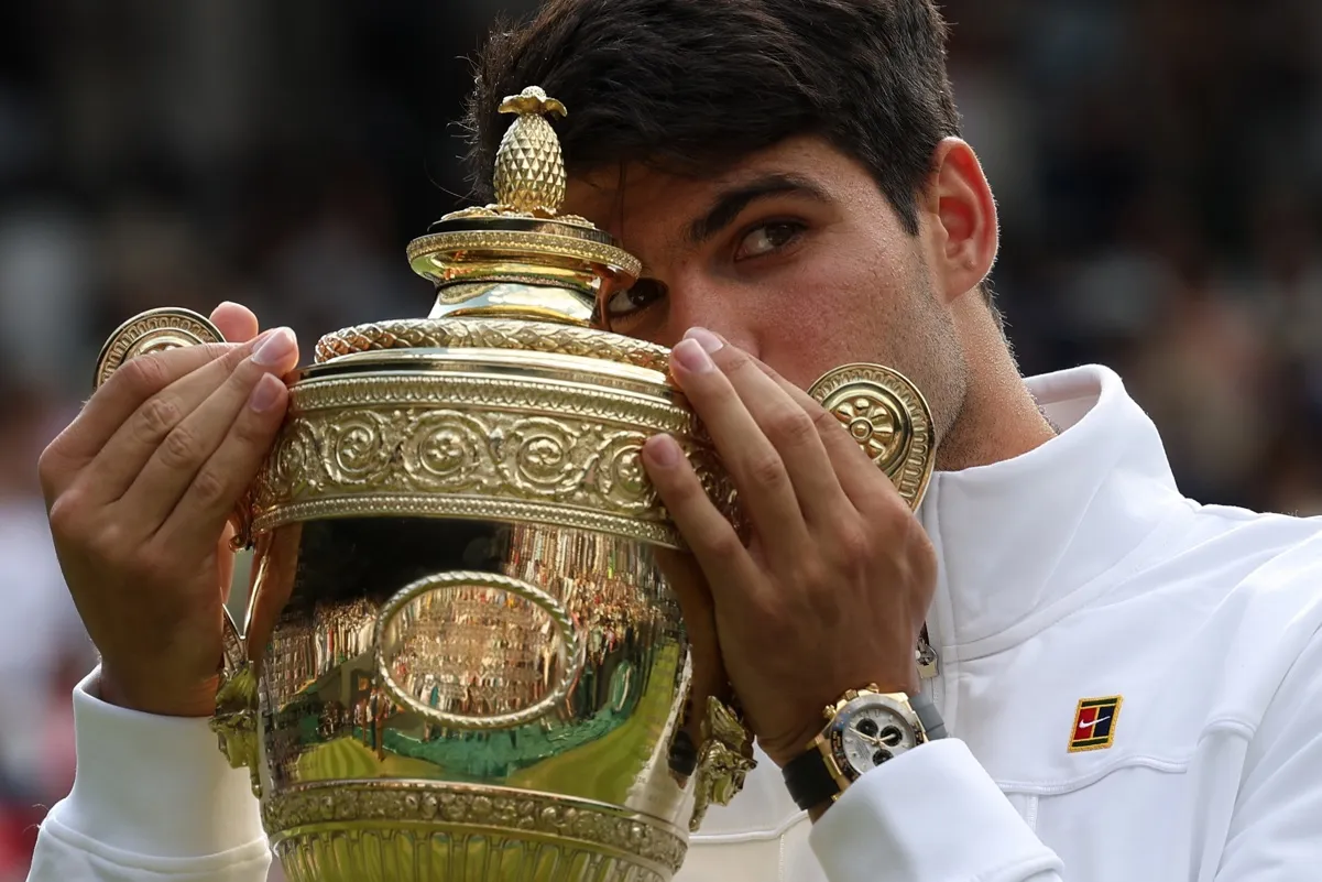 Carlos Alcaraz besa su trofeo en Wimbledon.