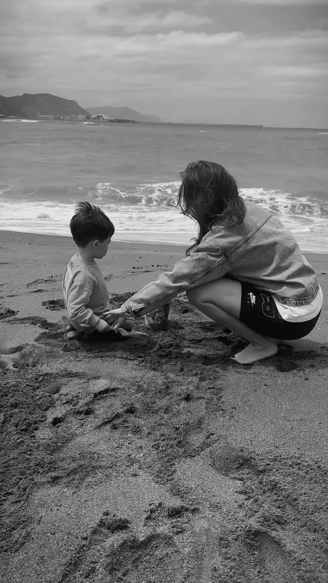 Jessica con su hijo jugando en la playa.