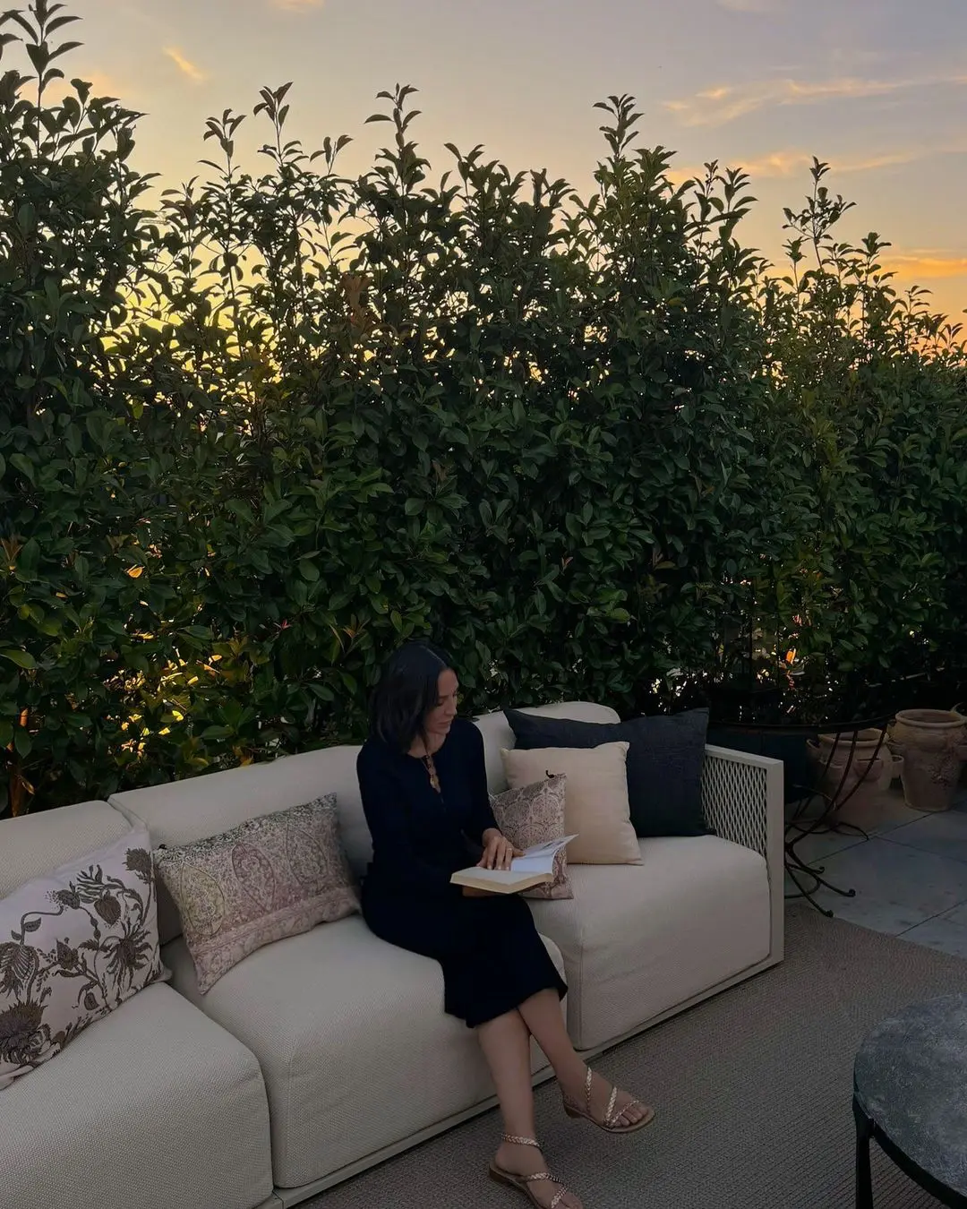 Tamara Falcó leyendo en el sofá de su terraza.