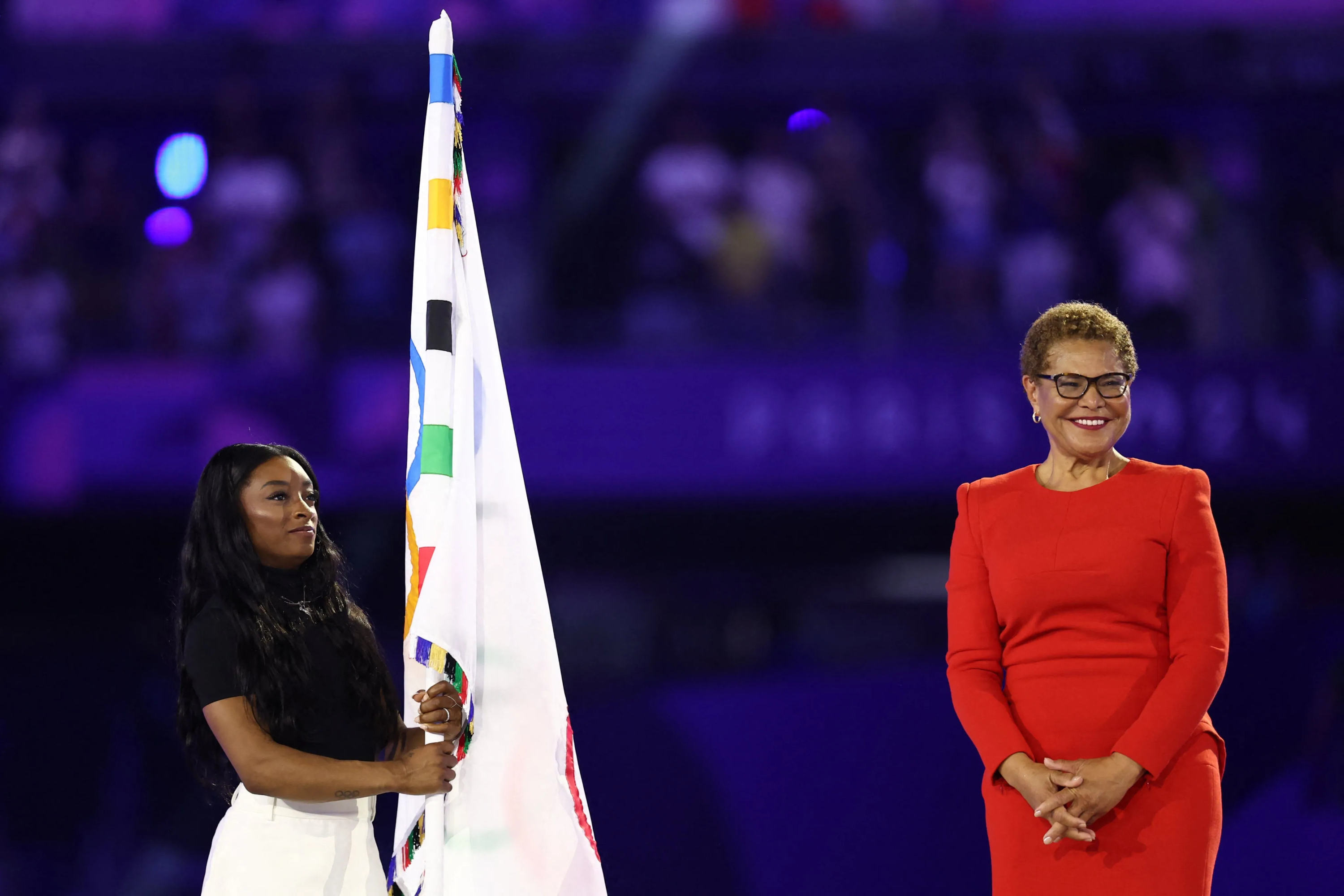 Simone Biles con la bandera y la alcaldesa de LA.