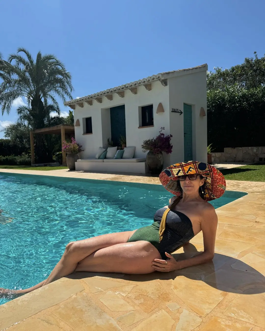 Paz Padilla posando en bañador junto a la piscina con un original gorro.