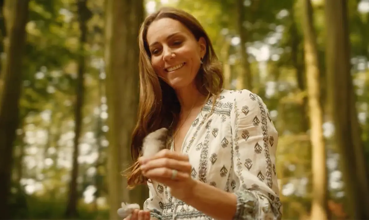 Kate Middleton sonriente con una pluma de ave en su mano