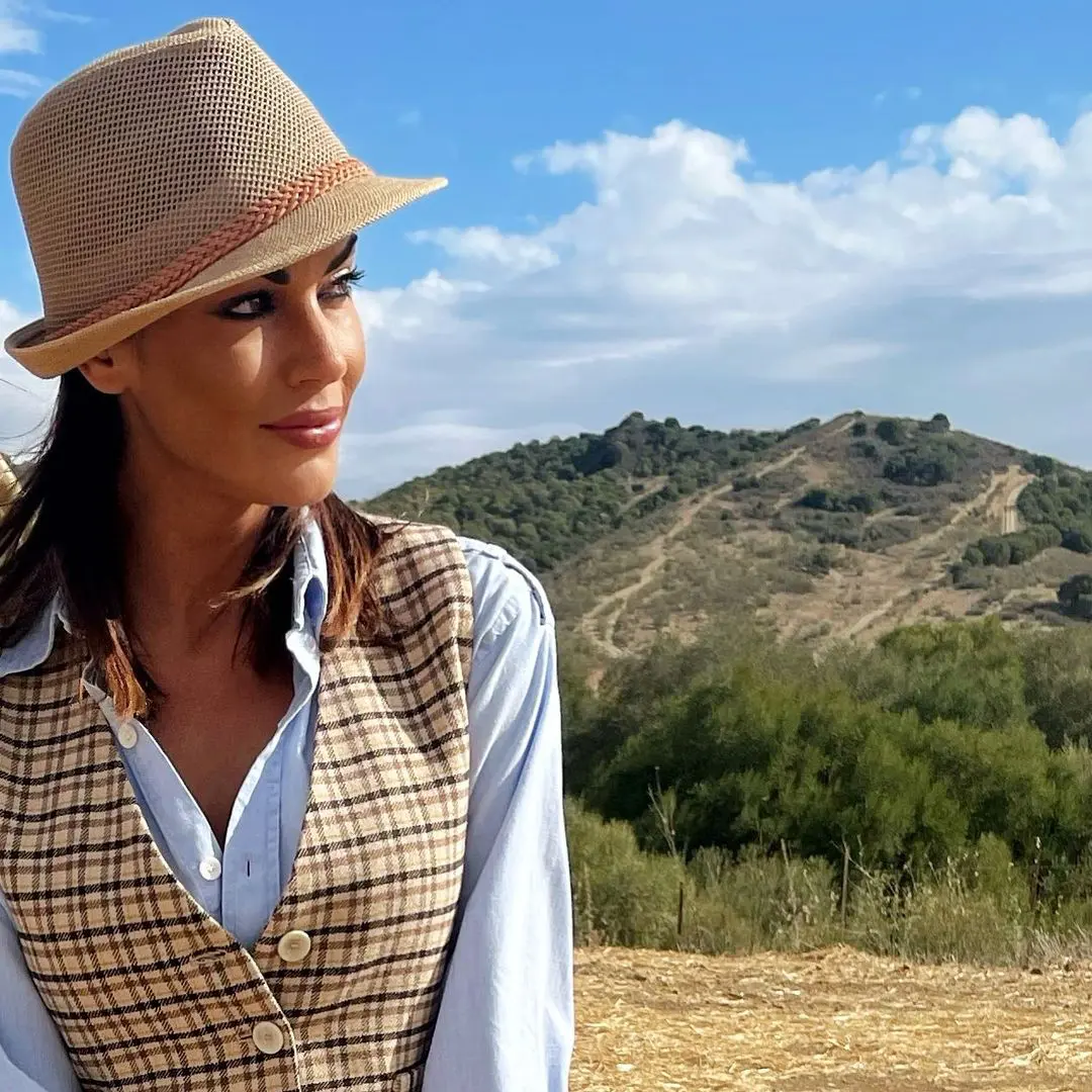 Con una imagen un poco distinta, Lara con sombrero y chaleco, en el campo.