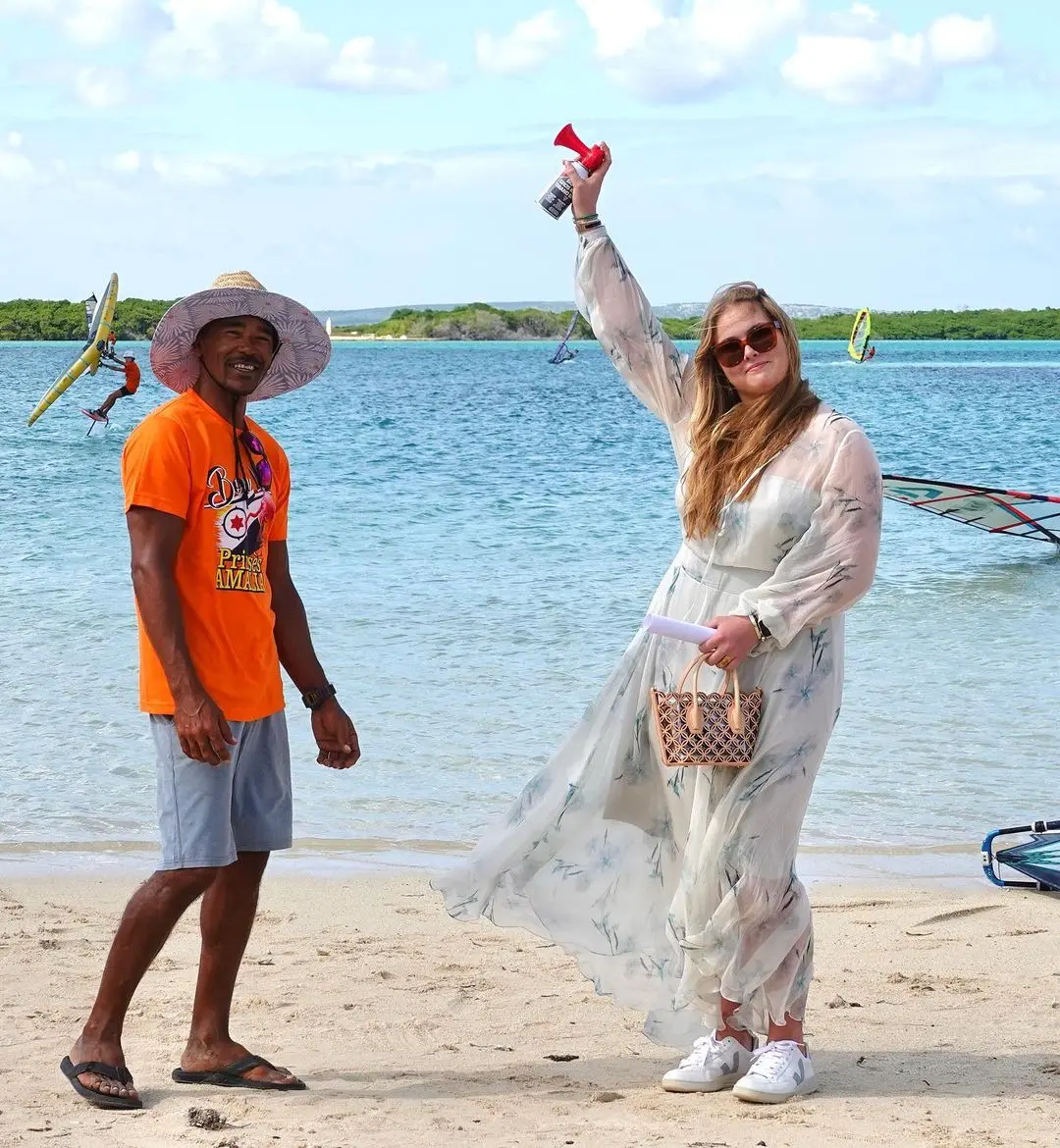 Con vestido estampado y zapatillas para poder andar en la playa.