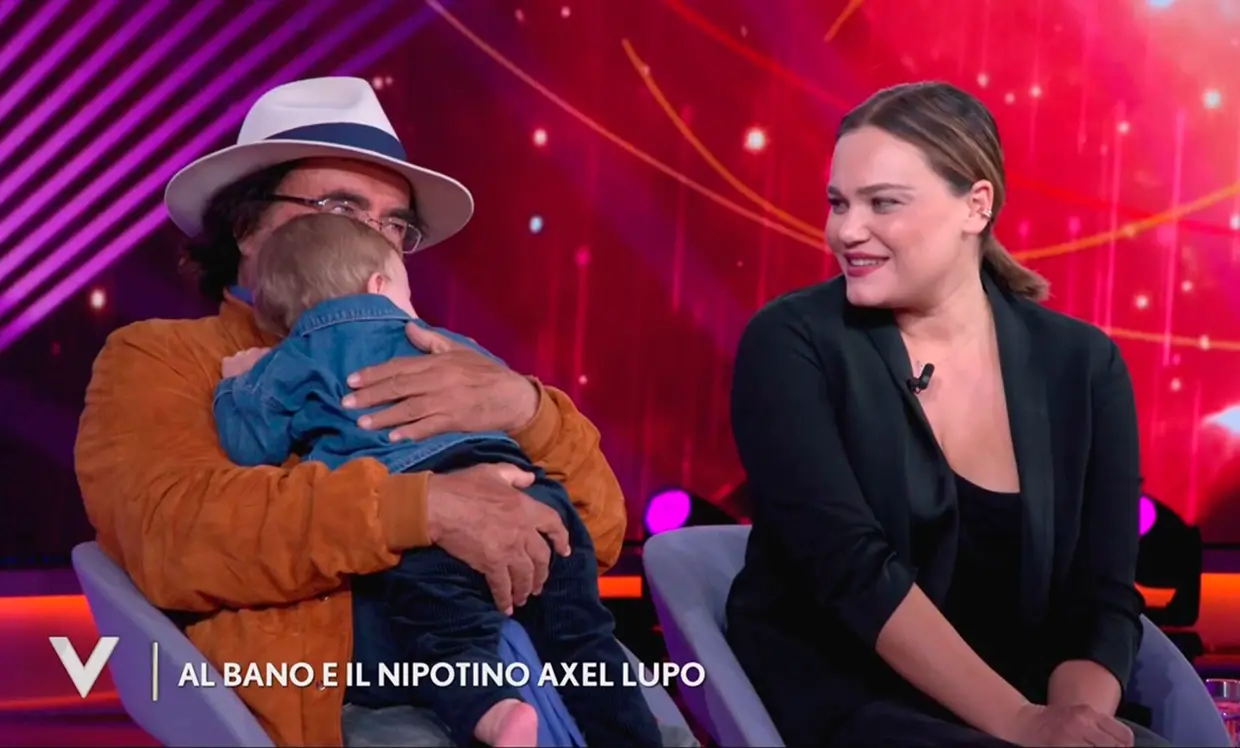 Al Bano abrazando a su nieto junto a su hija en un plató de televisión.