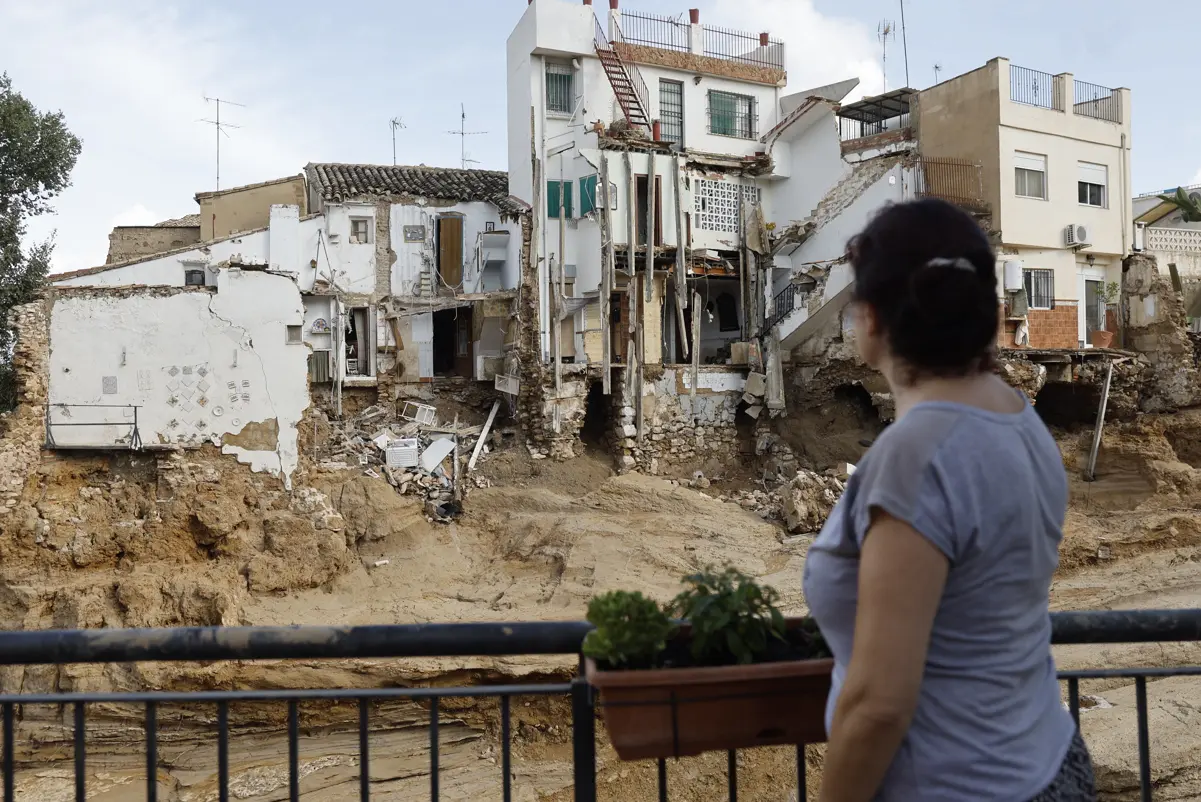 Una mujer observa varias casas dañadas en Chiva tras la DANA.