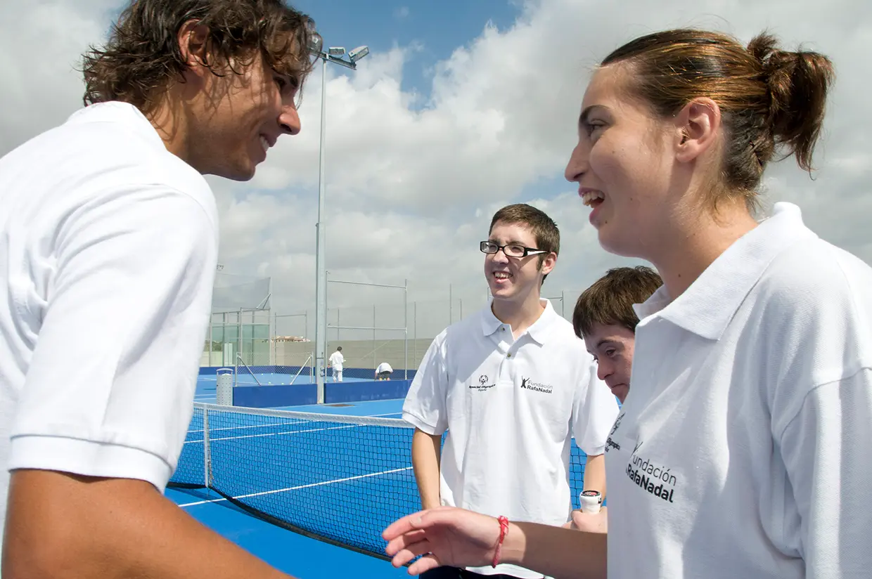 Rafa Nadal en su fundación con una chica y un chico con diversidad funcional.