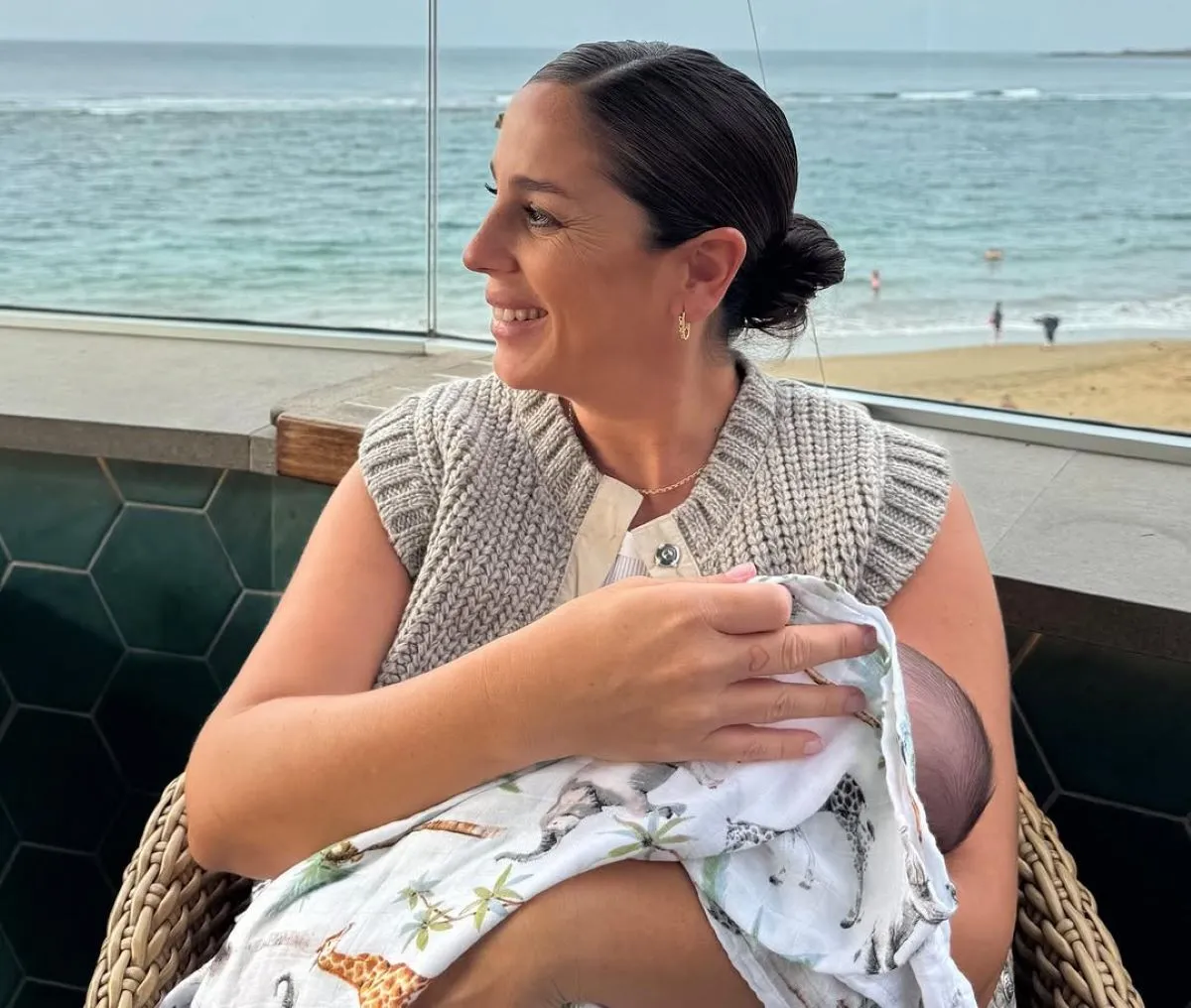 Anabel Pantoja en una terraza con vistas al mar con su hija Alma